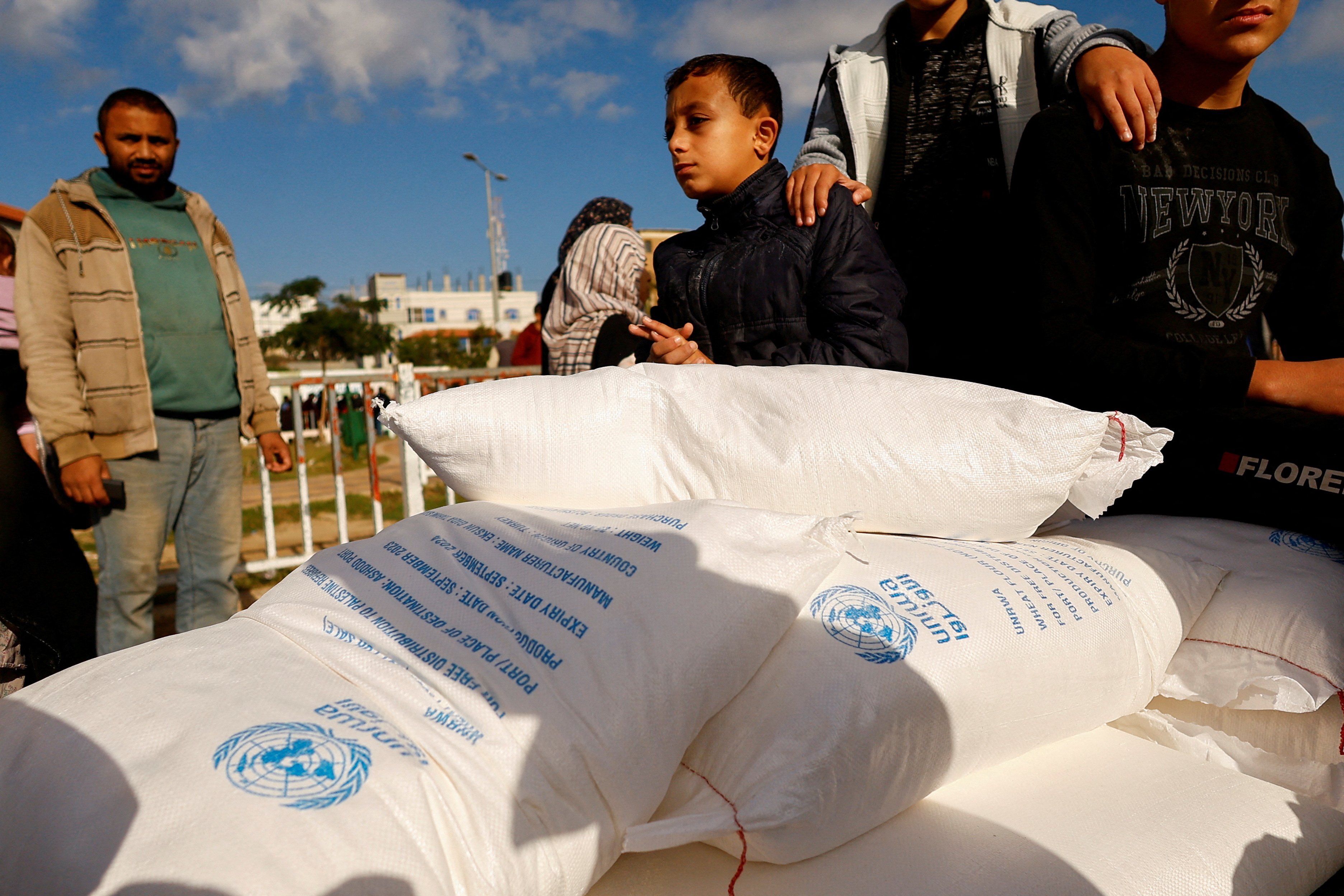 FILE PHOTO: Palestinians gather to receive flour bags distributed by UNRWA in Rafah
