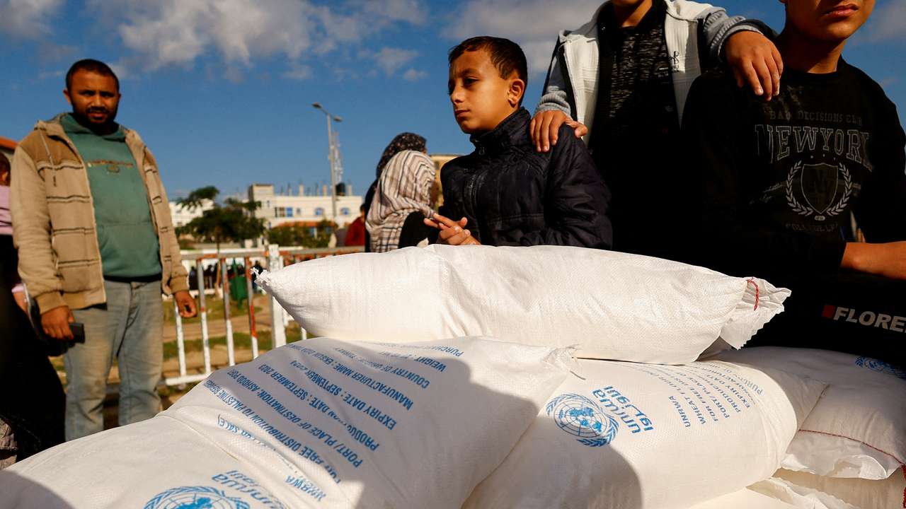 FILE PHOTO: Palestinians gather to receive flour bags distributed by UNRWA in Rafah