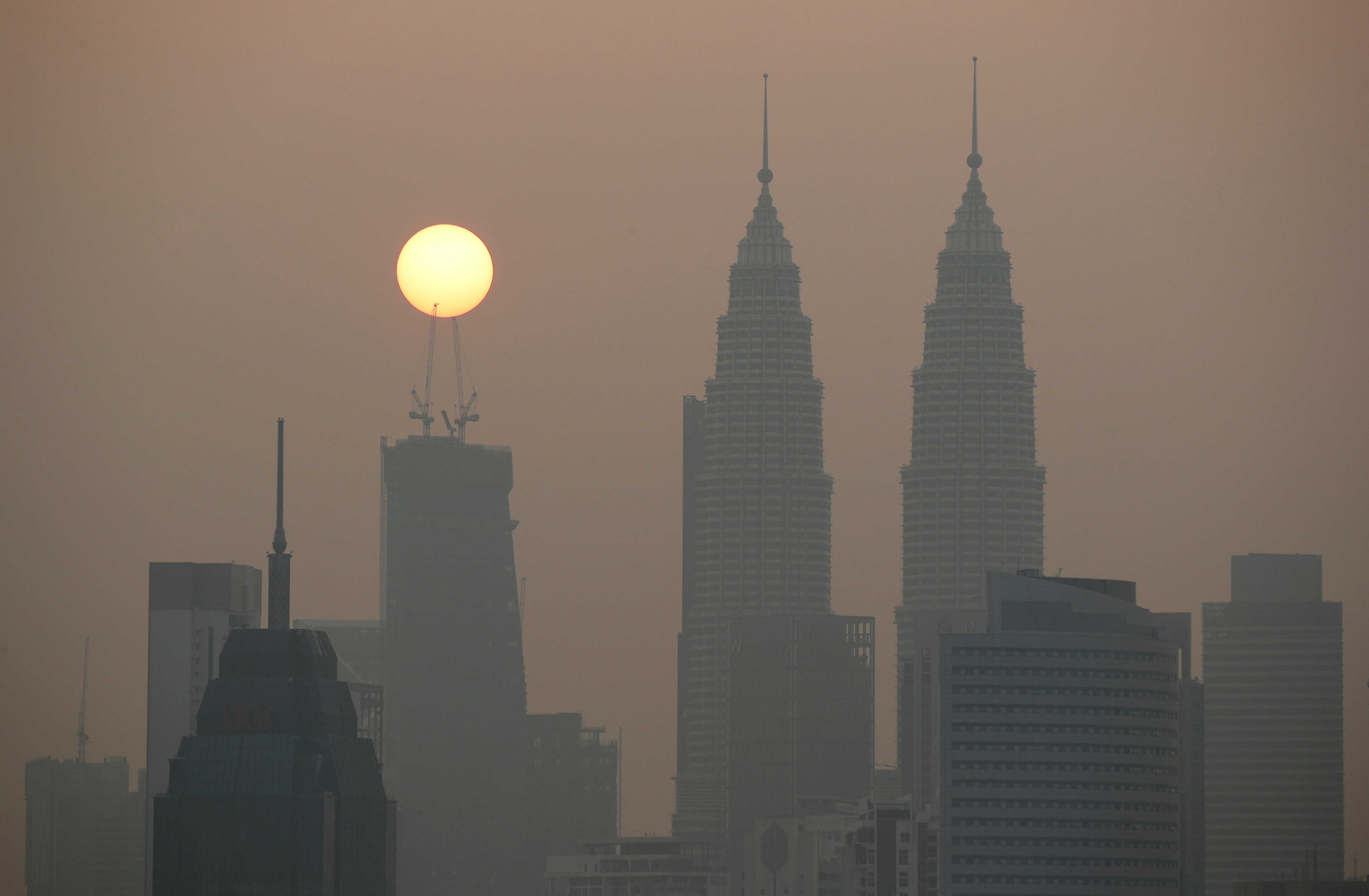 Sun rises above Kuala Lumpur's skyline on a hazy day in Kuala Lumpur