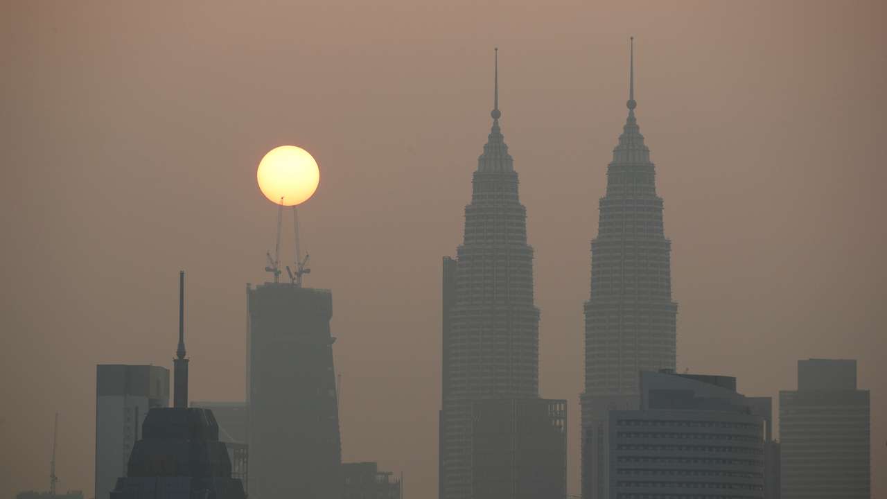 Sun rises above Kuala Lumpur's skyline on a hazy day in Kuala Lumpur