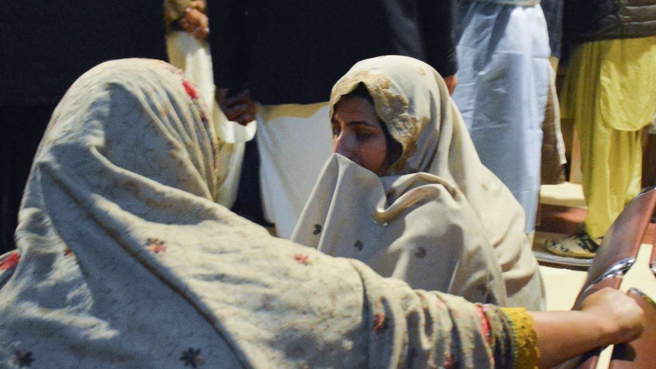 Passengers who were rescued from a train after it was attacked by separatist militants, sit at the Railway Station in Quetta