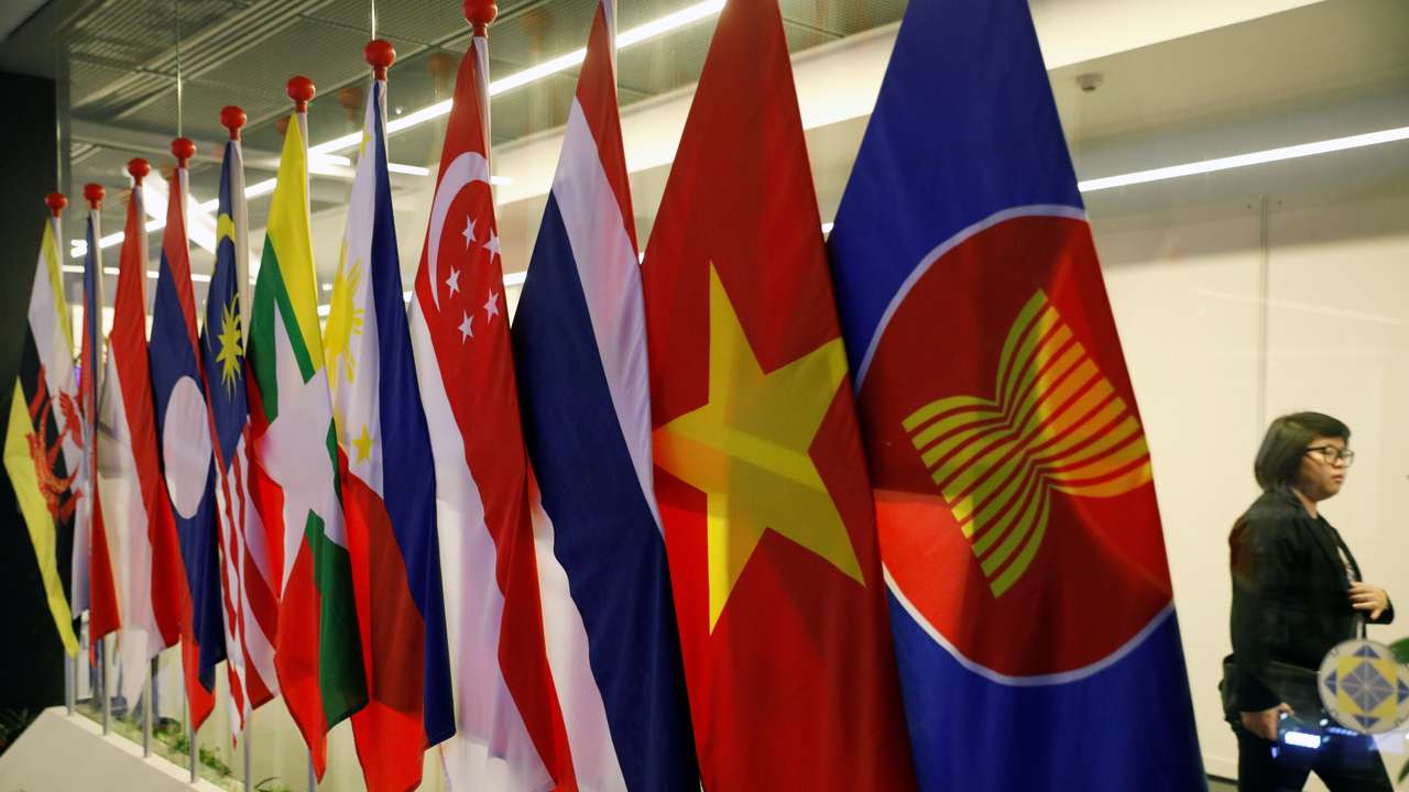 A woman passes ASEAN Summit flags at Suntec Convention Centre in Singapore