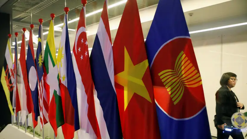 A woman passes ASEAN Summit flags at Suntec Convention Centre in Singapore