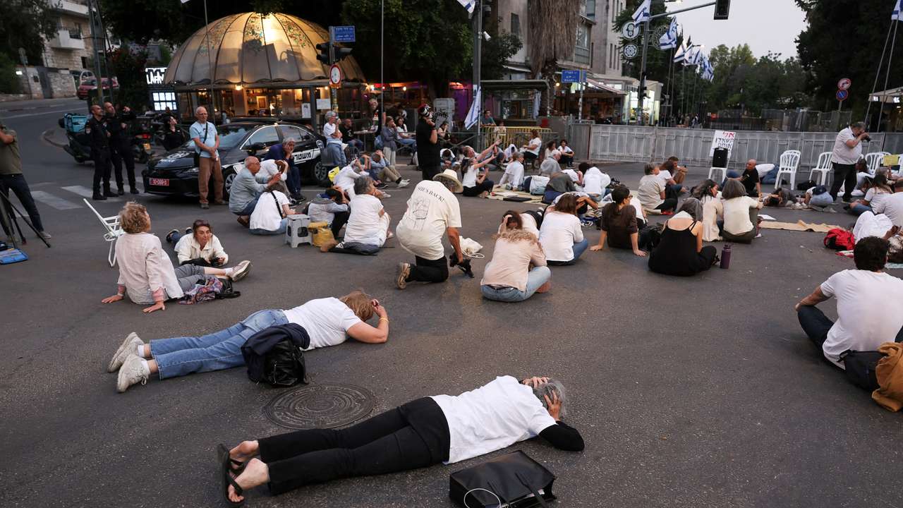 People lie on the floor as they take cover, while sirens sound, in Jerusalem