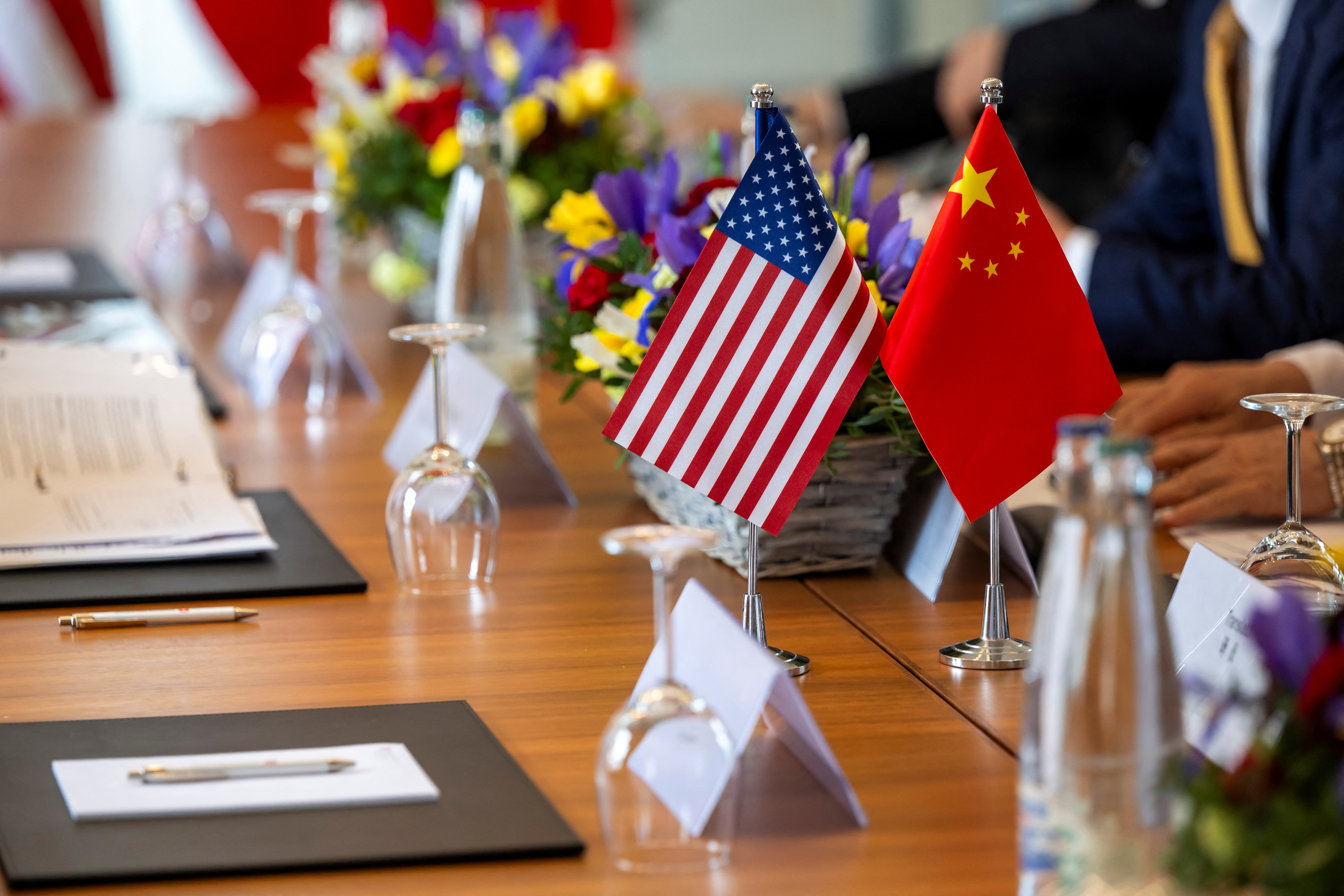 The American and Chinese flags are photographed on the negotiating table, during a bilateral meeting between the United States and China, in Geneva