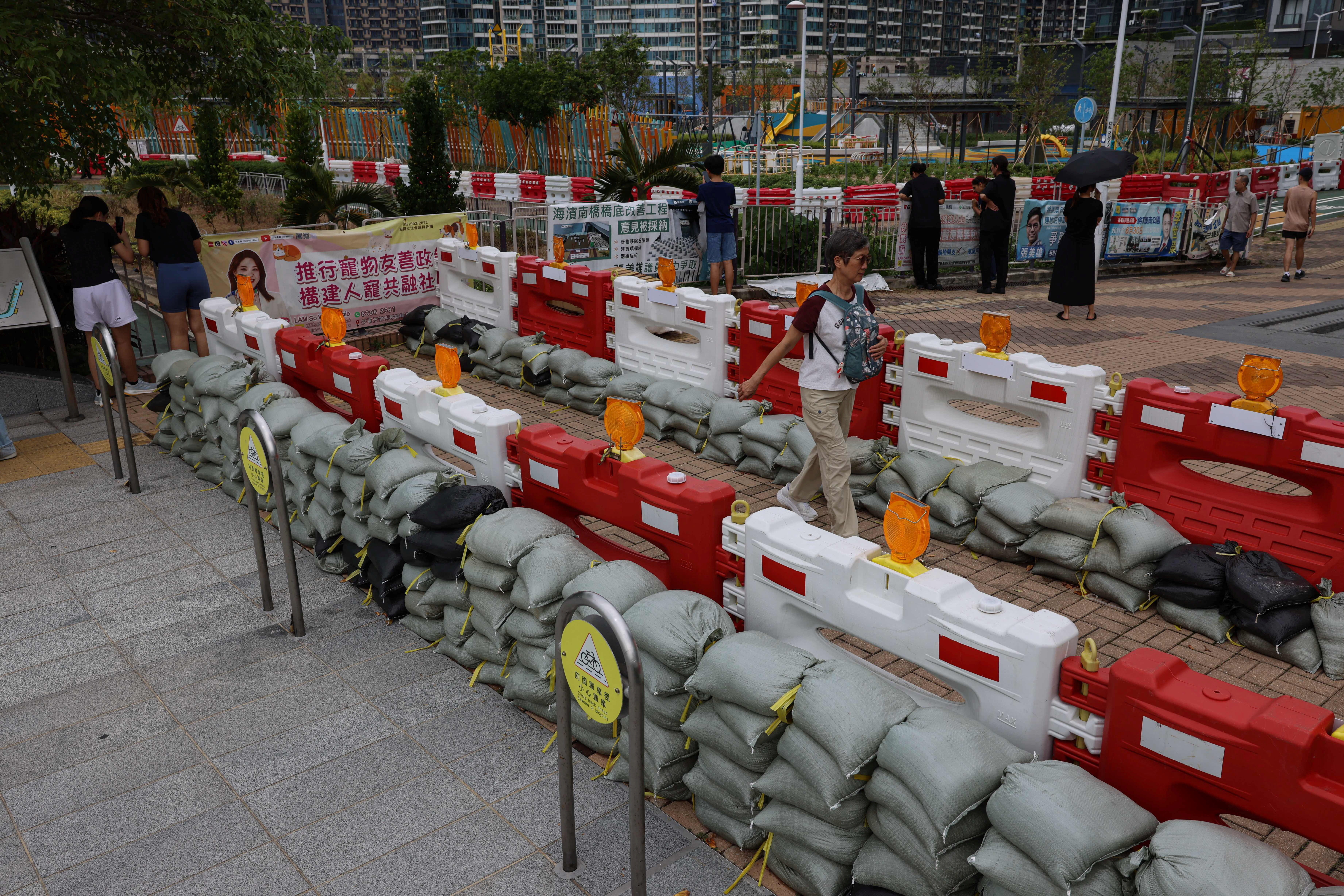 Residents walk past sandbags placed to prevent flooding from Super Typhoon Ragasa in Hong Kong