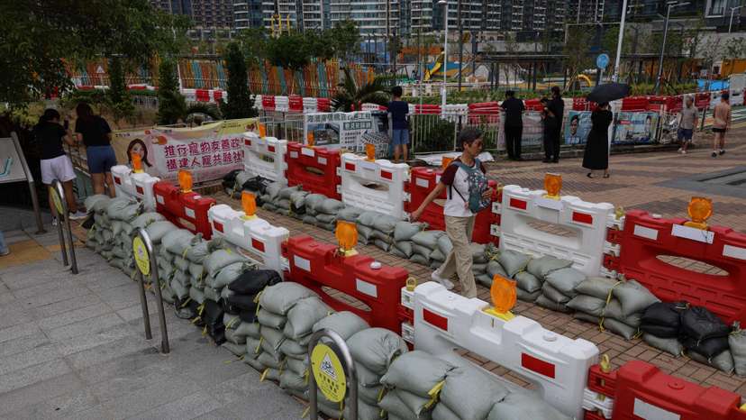 Residents walk past sandbags placed to prevent flooding from Super Typhoon Ragasa in Hong Kong