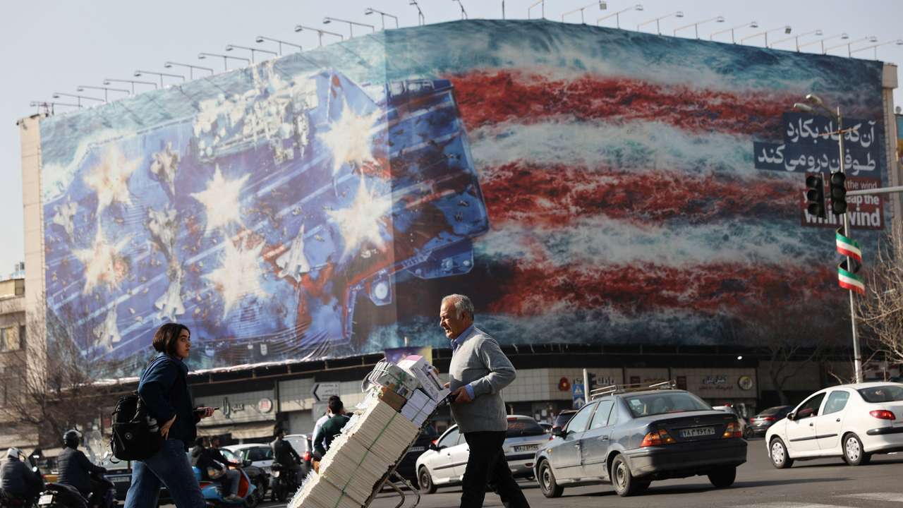 People walk past an anti-U.S. billboard in Tehran