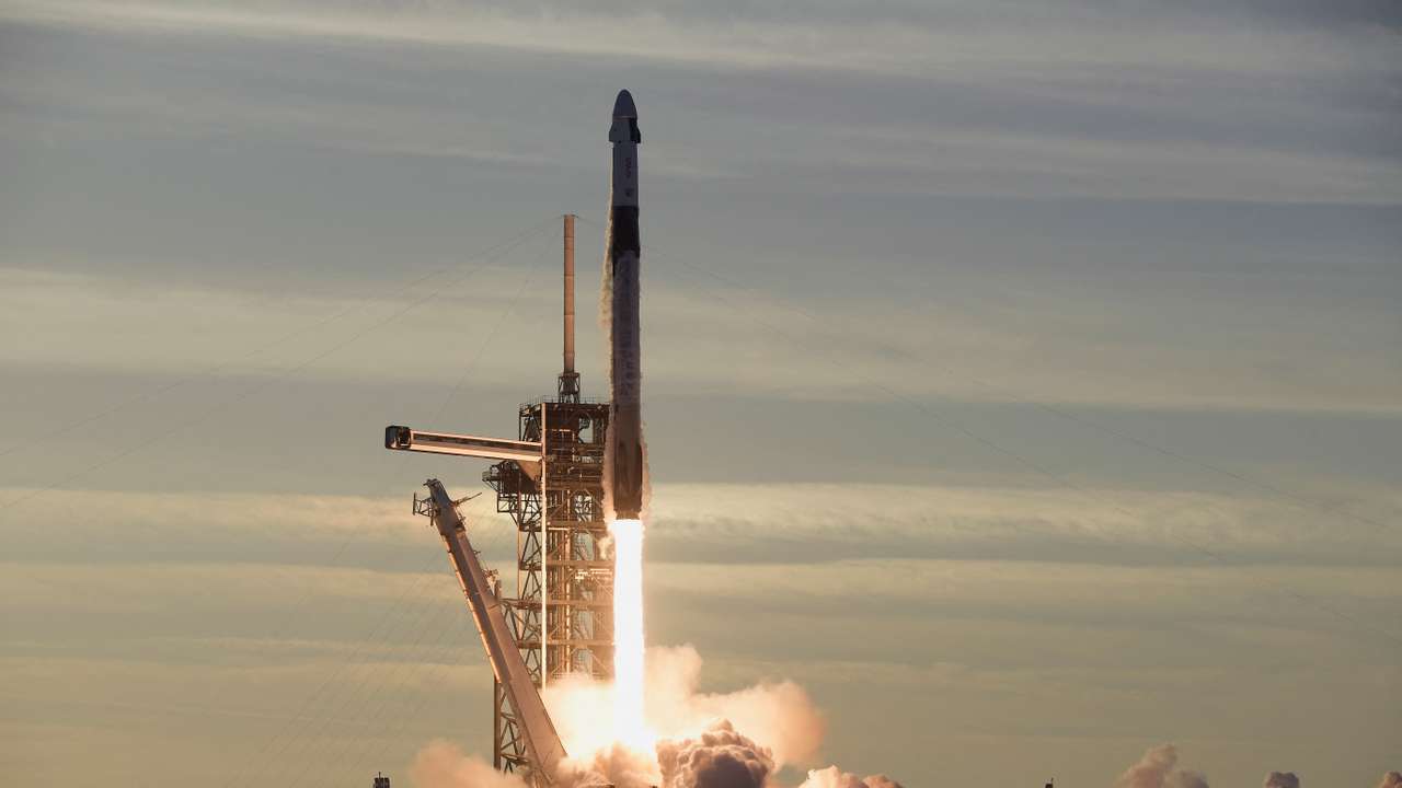 A SpaceX Falcon 9 rocket carrying a crew of four lifts off from Launch Complex 39-A