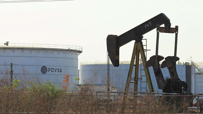 An oil pumpjack and a tank with the corporate logo of state oil company PDVSA are seen in an oil facility in Lagunillas