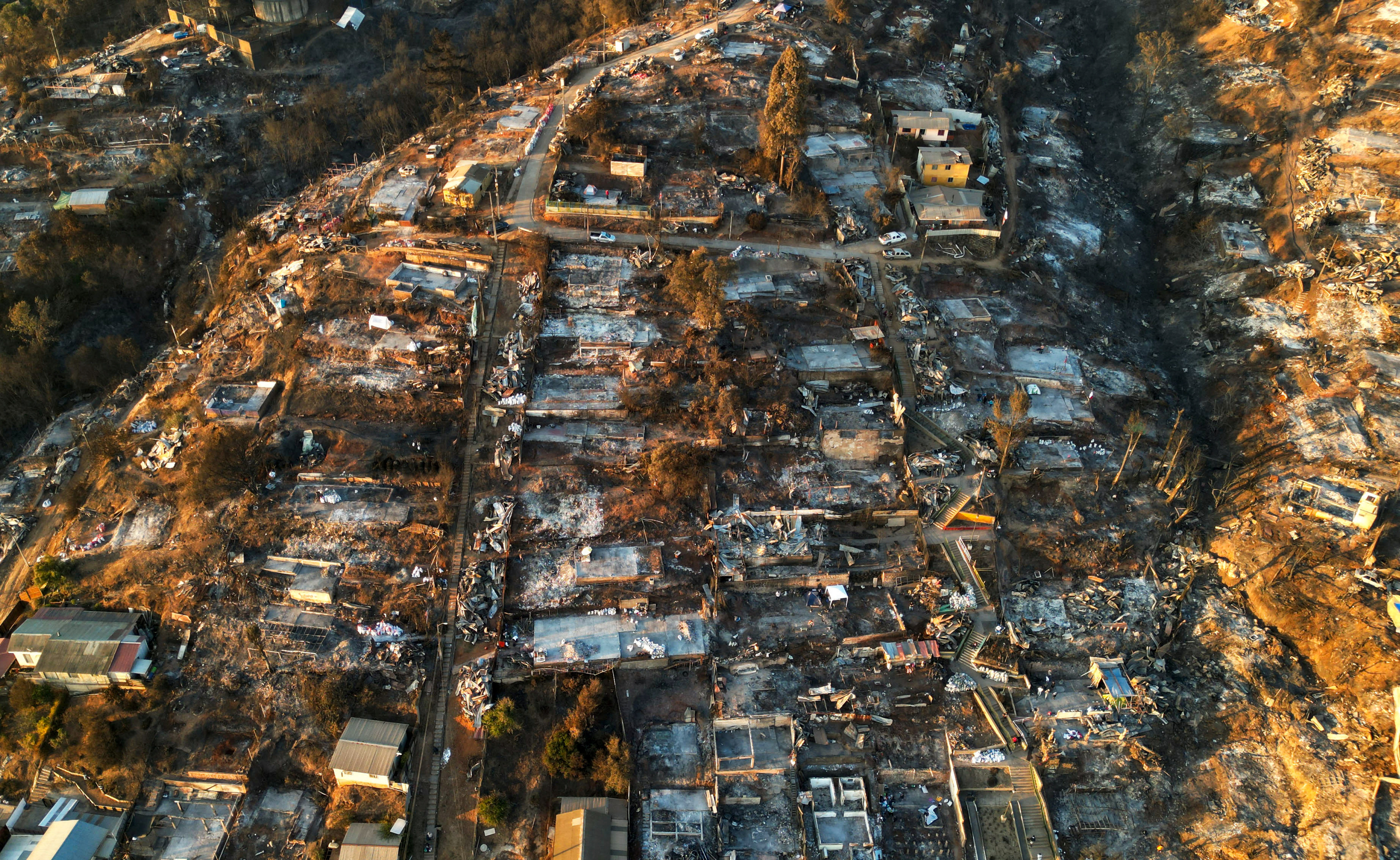 An aerial view shows the remains of houses burnt following the spread of wildfires in Vina del Mar