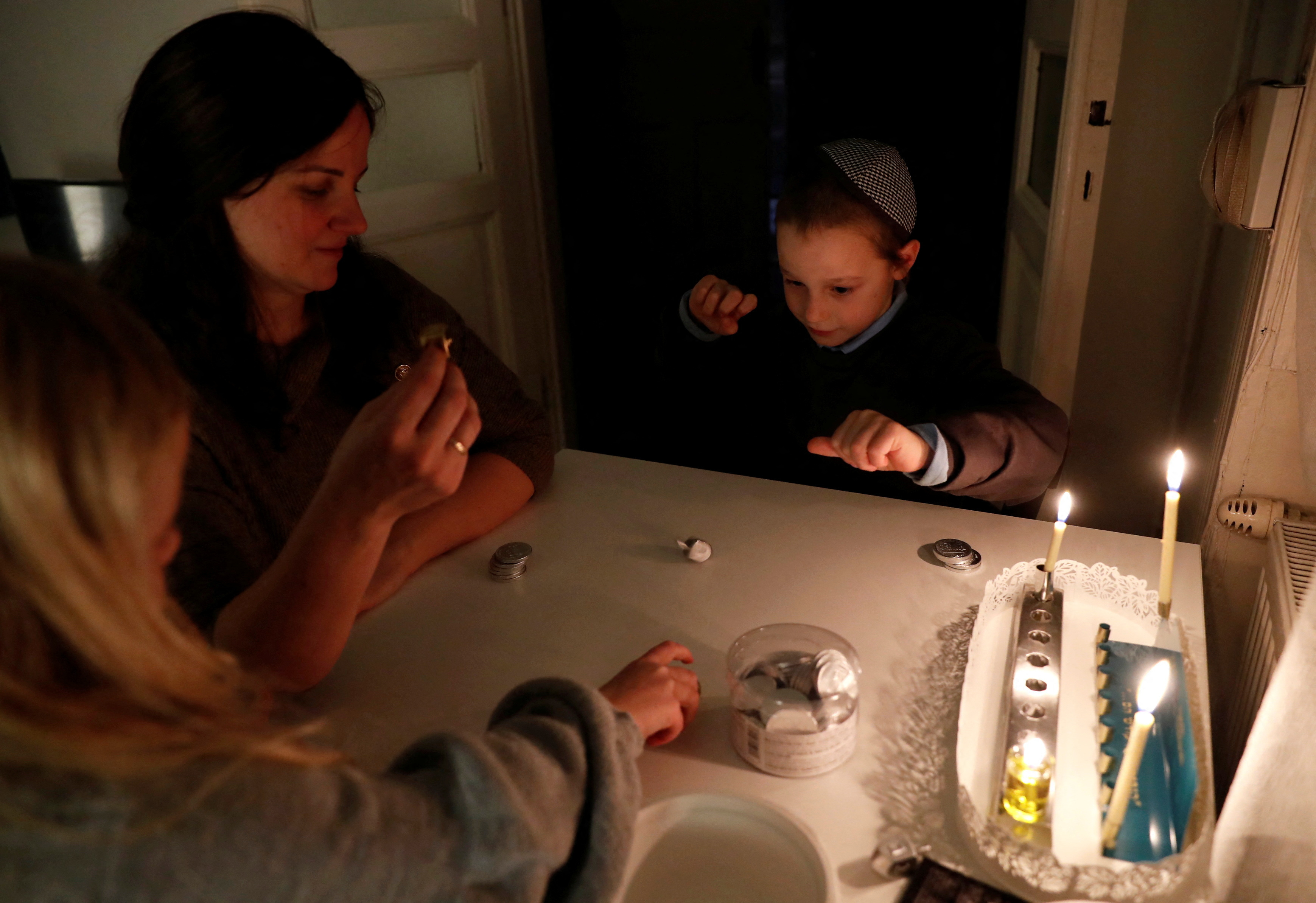 Ruth, a Hungarian-born Jewish musician, who have come to Hungary after the October 7 attacks, celebrates the first night of the Jewish holiday of Hanukkah with her children, in Budapest
