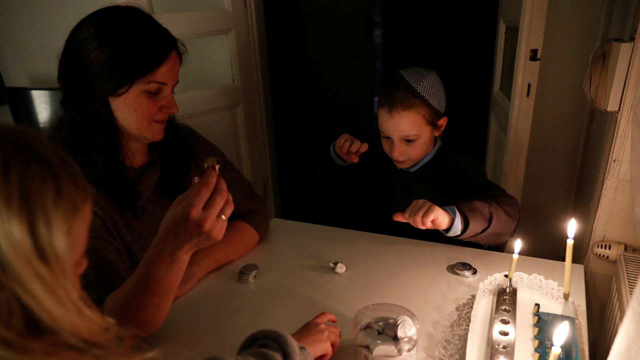 Ruth, a Hungarian-born Jewish musician, who have come to Hungary after the October 7 attacks, celebrates the first night of the Jewish holiday of Hanukkah with her children, in Budapest