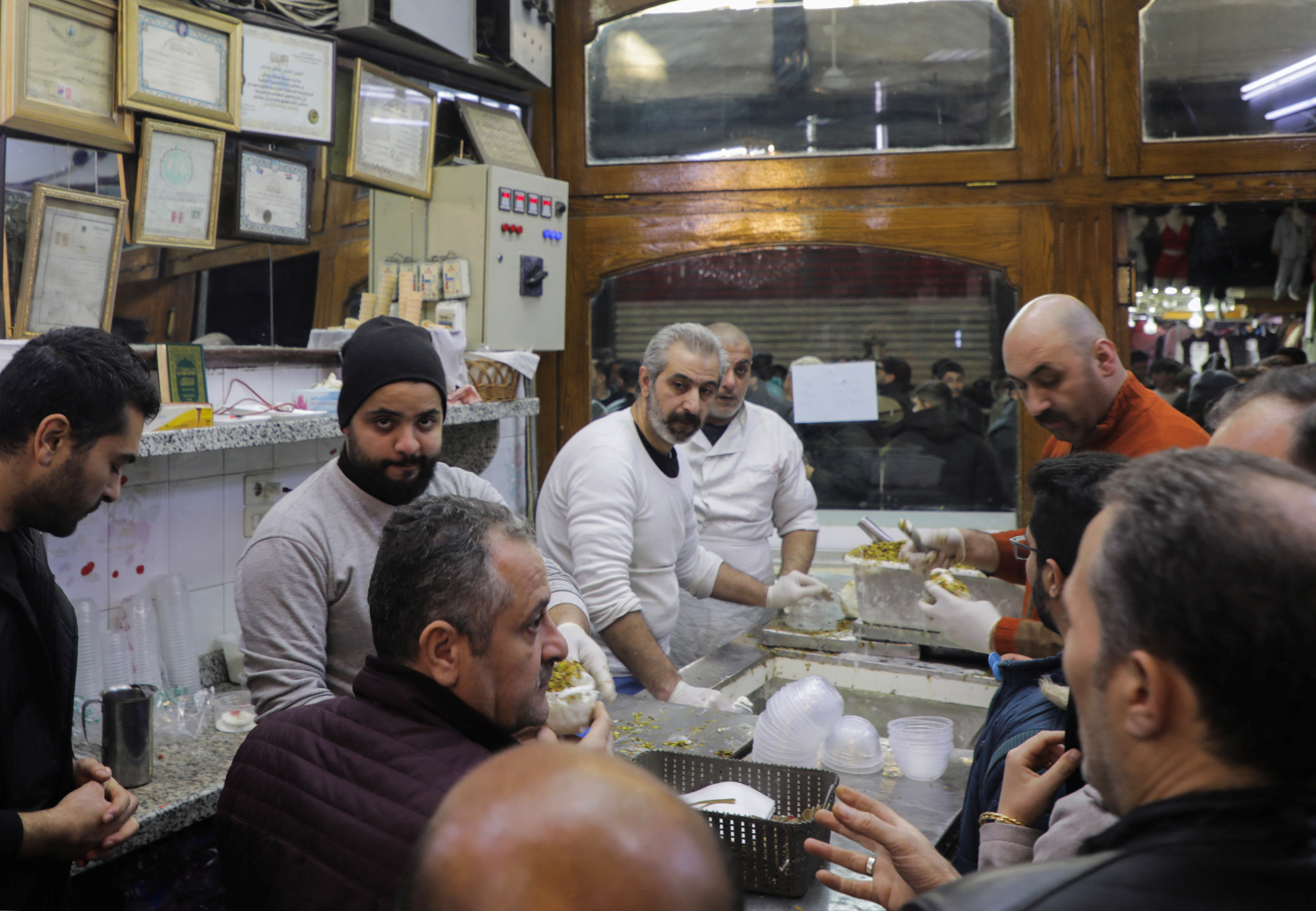 People gather at Bakdash ice-cream parlour, in Hamidiyeh Souk