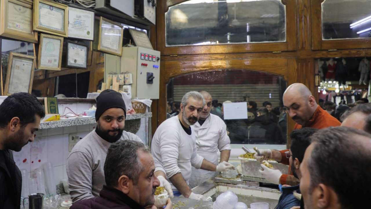People gather at Bakdash ice-cream parlour, in Hamidiyeh Souk