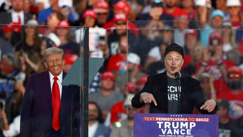 FILE PHOTO: Tesla CEO and X owner Elon Musk speaks as Donald Trump reacts during a rally in Butler