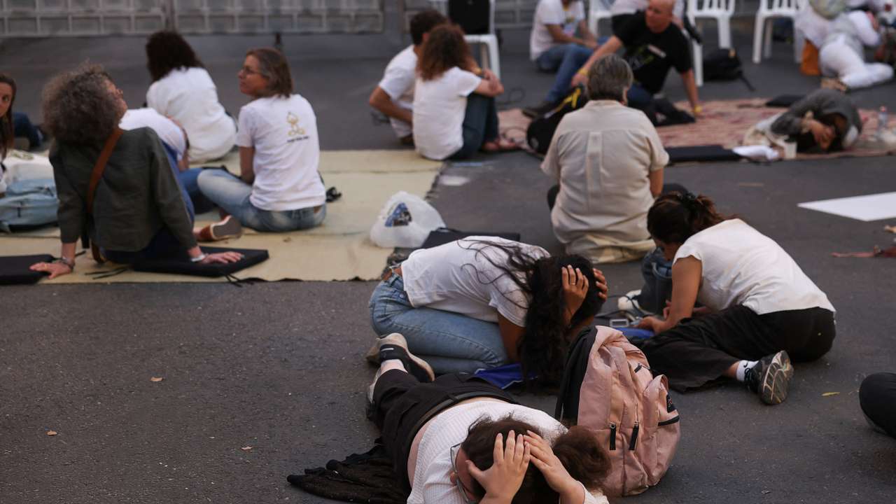 People lie on the floor as they take cover, while sirens sound, in Jerusalem