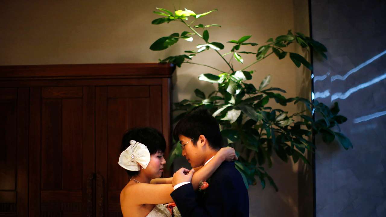 A couple prepares to participate in a staged mass wedding in Shanghai