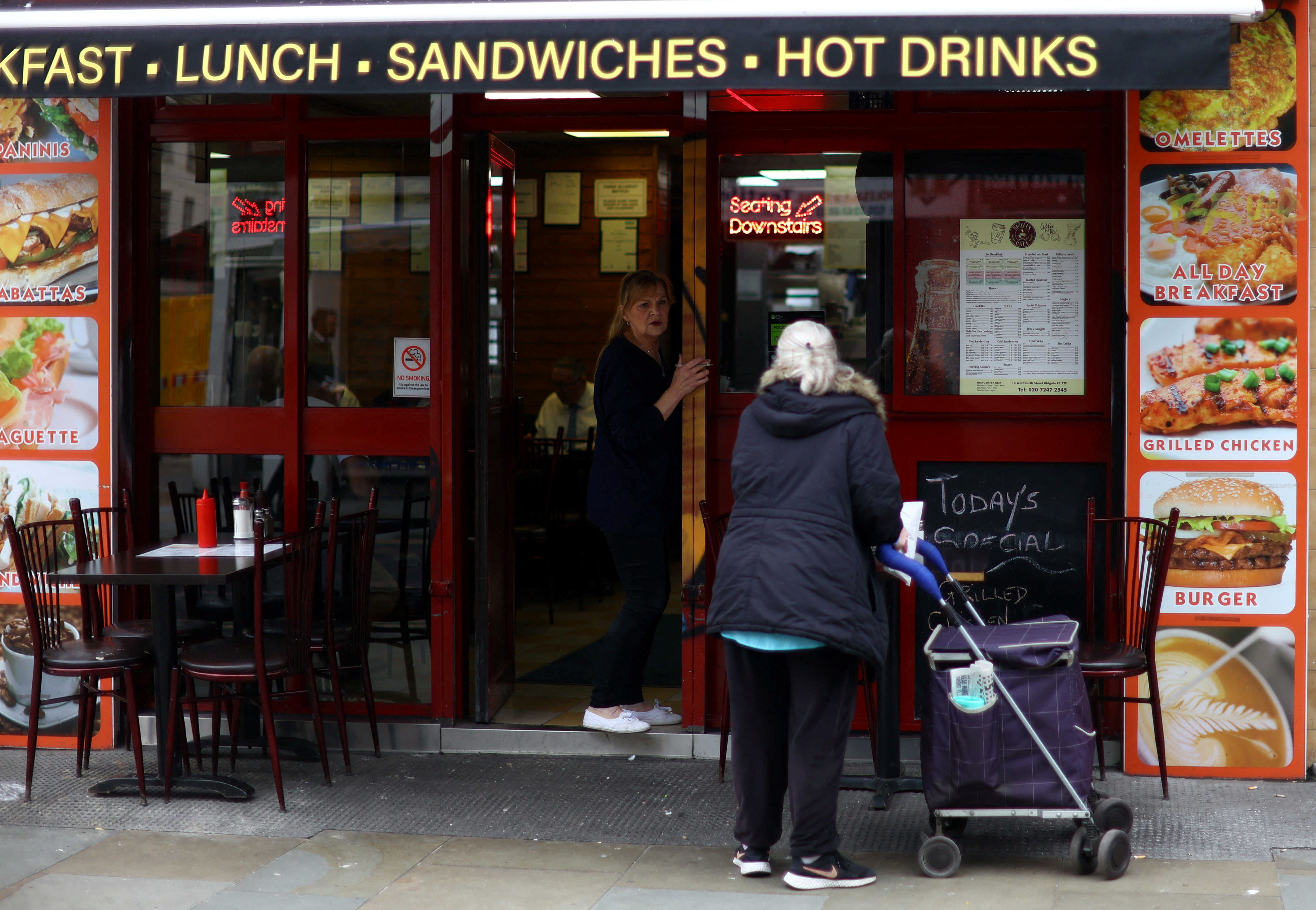 A woman buys food from a cafe in London