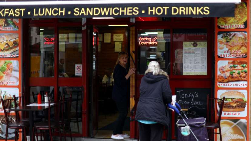 A woman buys food from a cafe in London