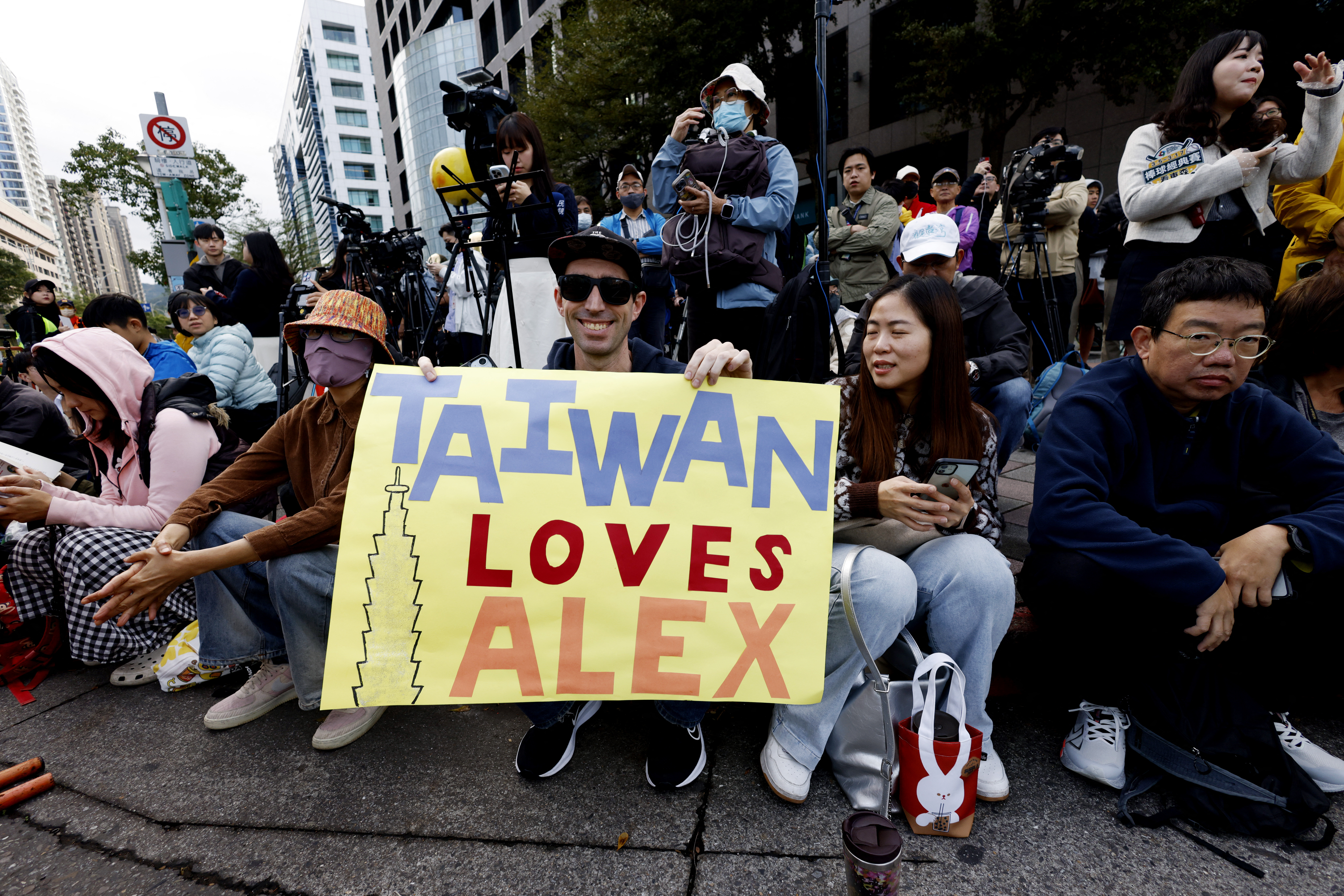 Climber Alex Honnold free soloing Taipei 101 Skyscraper