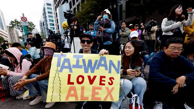 Climber Alex Honnold free soloing Taipei 101 Skyscraper