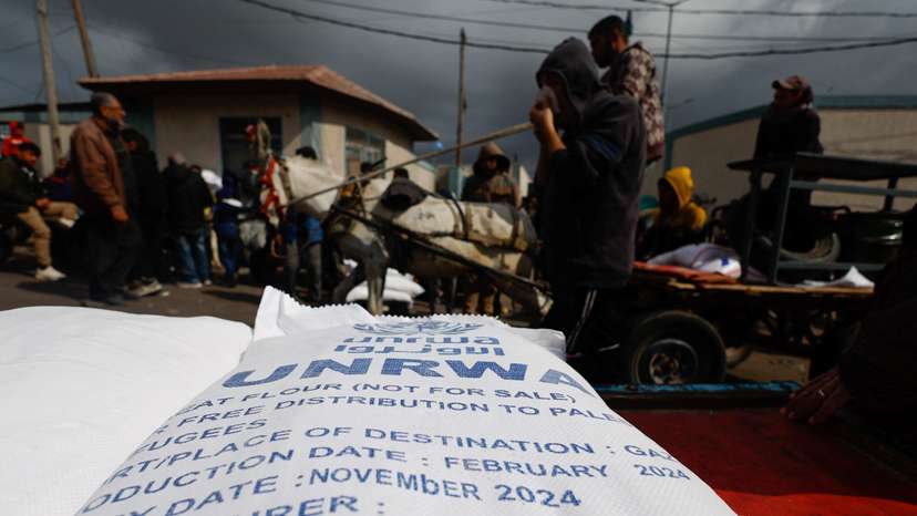 Displaced Palestinians wait to receive United Nations Relief and Works Agency (UNRWA) aid, in Rafah