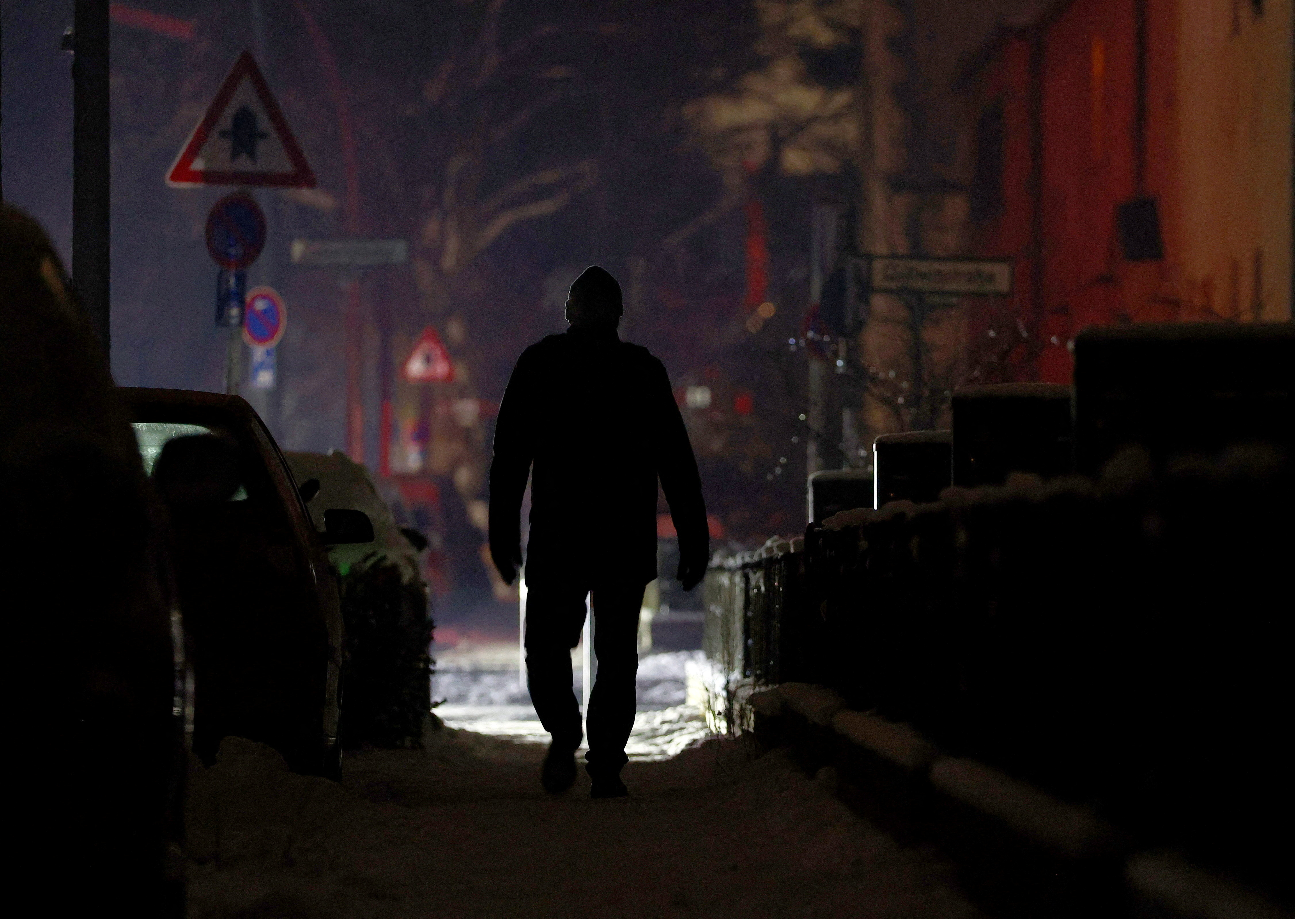 FILE PHOTO: A person walks along a street during a blackout in Berlin
