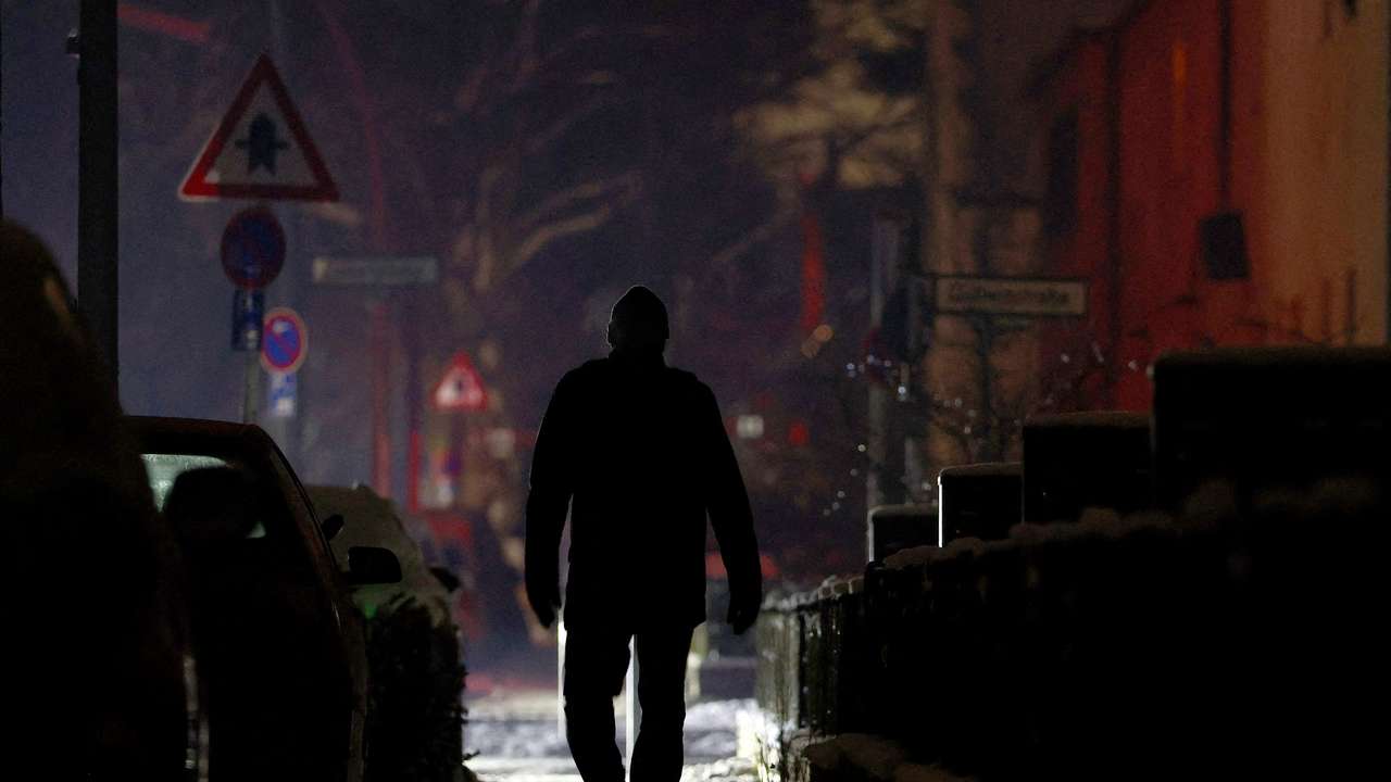 FILE PHOTO: A person walks along a street during a blackout in Berlin
