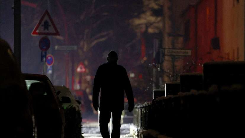 FILE PHOTO: A person walks along a street during a blackout in Berlin