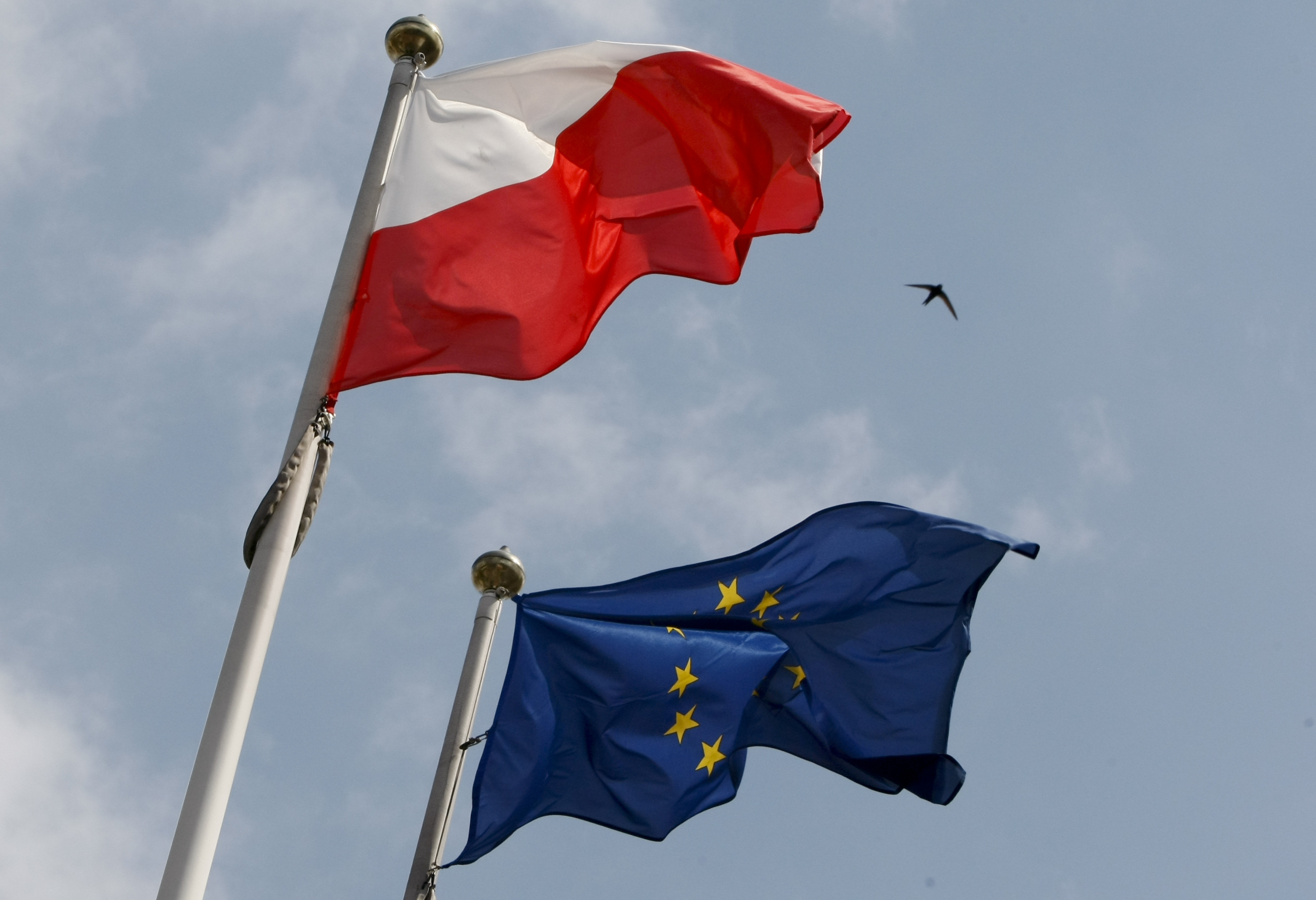 The flags of Poland and European Union flutter in front of the Polish parliament in Warsaw