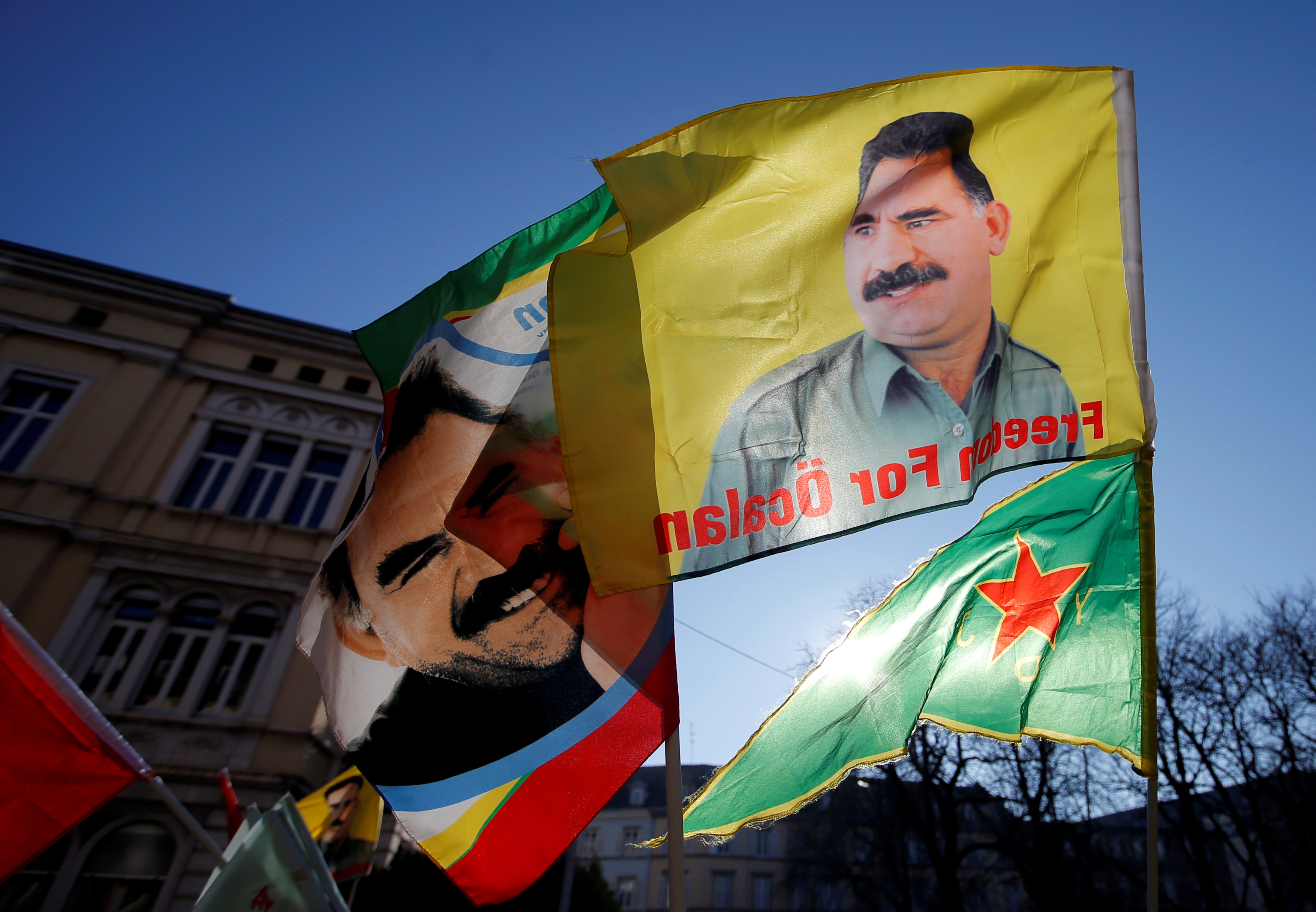 Pro-Kurd protesters hold flags with portraits of jailed PKK leader Ocalan as they take part in a demonstration in support to him in Strasbourg