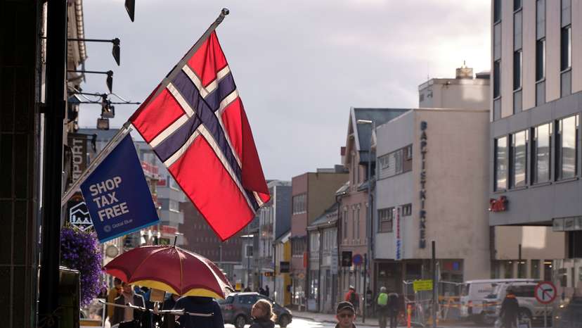 A Norwegian flag flutters over a shop in Tromso