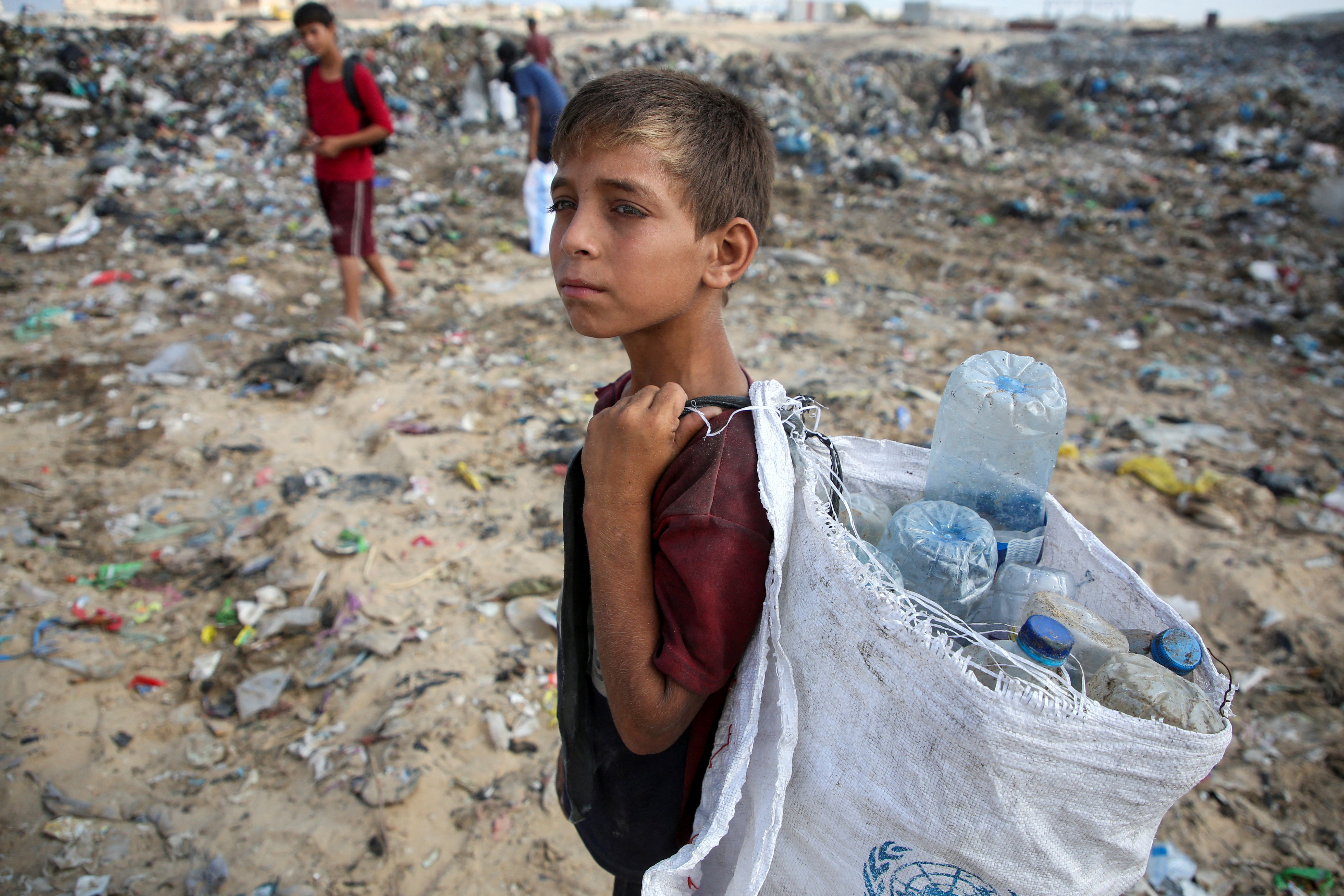 Palestinians scavenge for usable items at a dump site, amid the Israel-Hamas conflict, in Khan Younis in the southern Gaza Strip