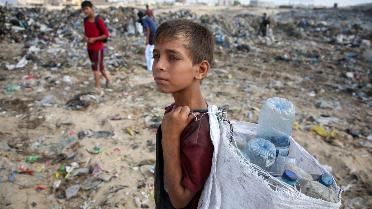 Palestinians scavenge for usable items at a dump site, amid the Israel-Hamas conflict, in Khan Younis in the southern Gaza Strip