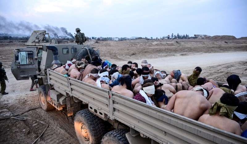 Israeli soldiers stand by truck with Palestinian detainees in the Gaza Strip
