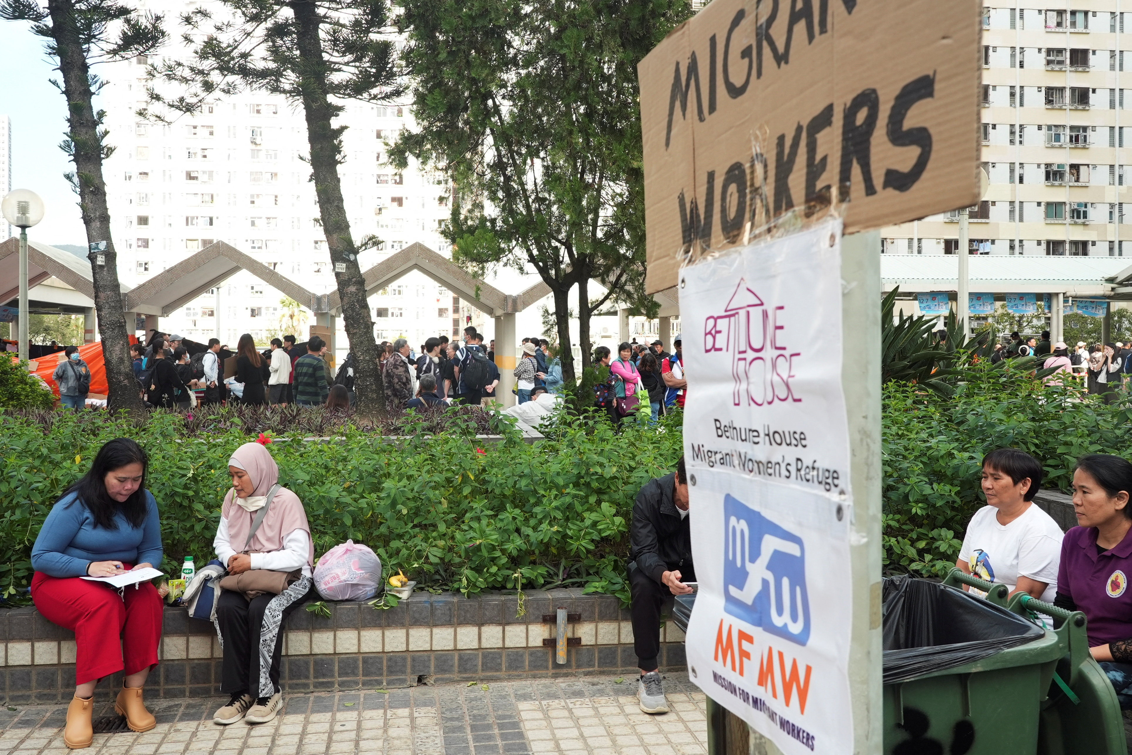 Volunteer gathers information from Fita, who escaped the deadly fire at Wang Fuk Court housing complex, in Hong Kong