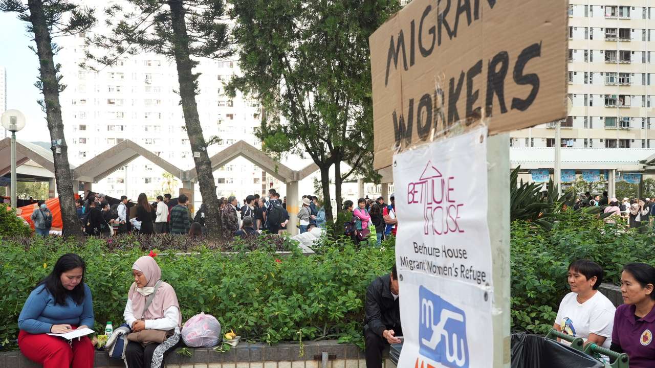 Volunteer gathers information from Fita, who escaped the deadly fire at Wang Fuk Court housing complex, in Hong Kong