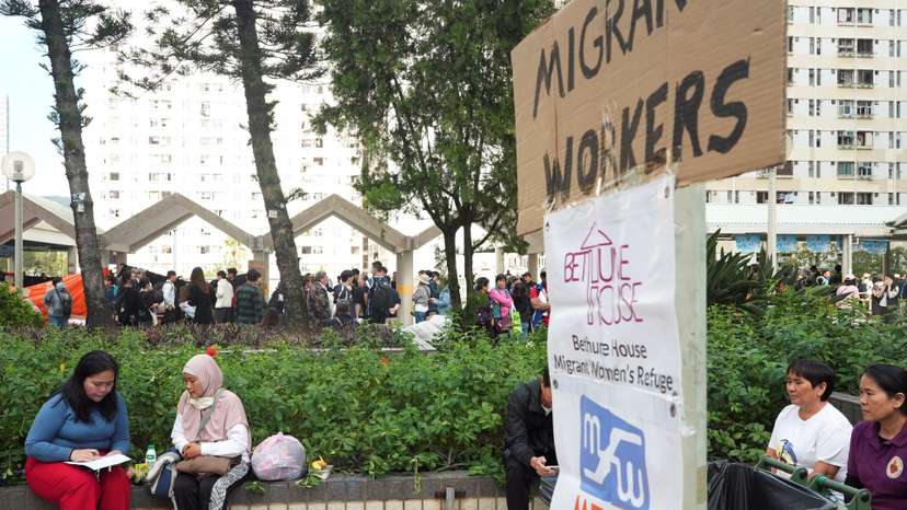 Volunteer gathers information from Fita, who escaped the deadly fire at Wang Fuk Court housing complex, in Hong Kong