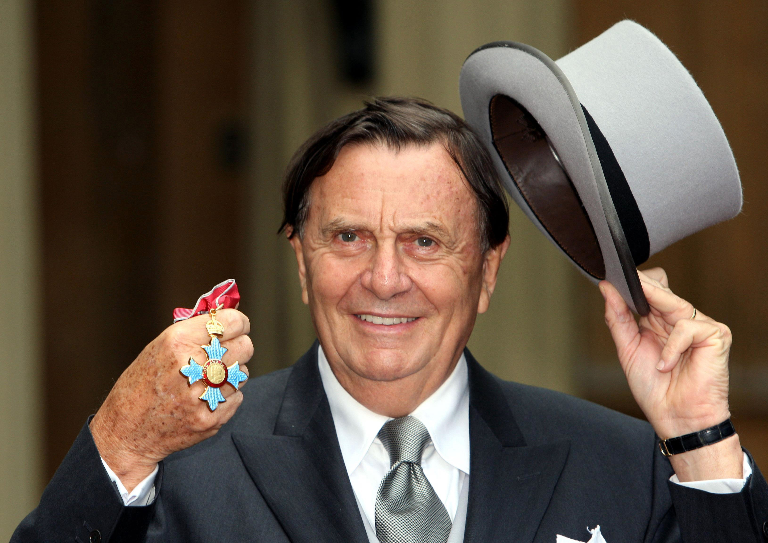Australia's Barry Humphries poses after receiving his Most Excellent Order of the British Empire from the Queen at Buckingham Palace, London