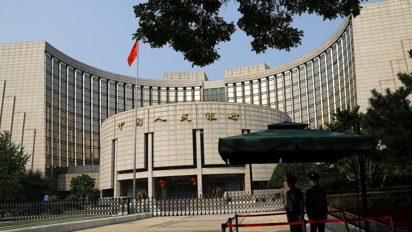 FILE PHOTO: Paramilitary police officers stand guard in front of the headquarters of PBOC in Beijing