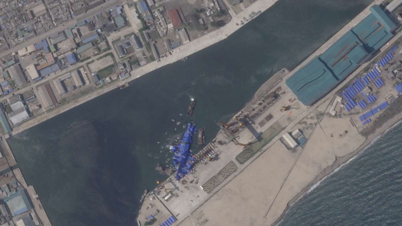 FILE PHOTO: A satellite image shows a North Korean warship covered with a blue tarp after an accident that occurred during its launch at the shipyard in Chongjin