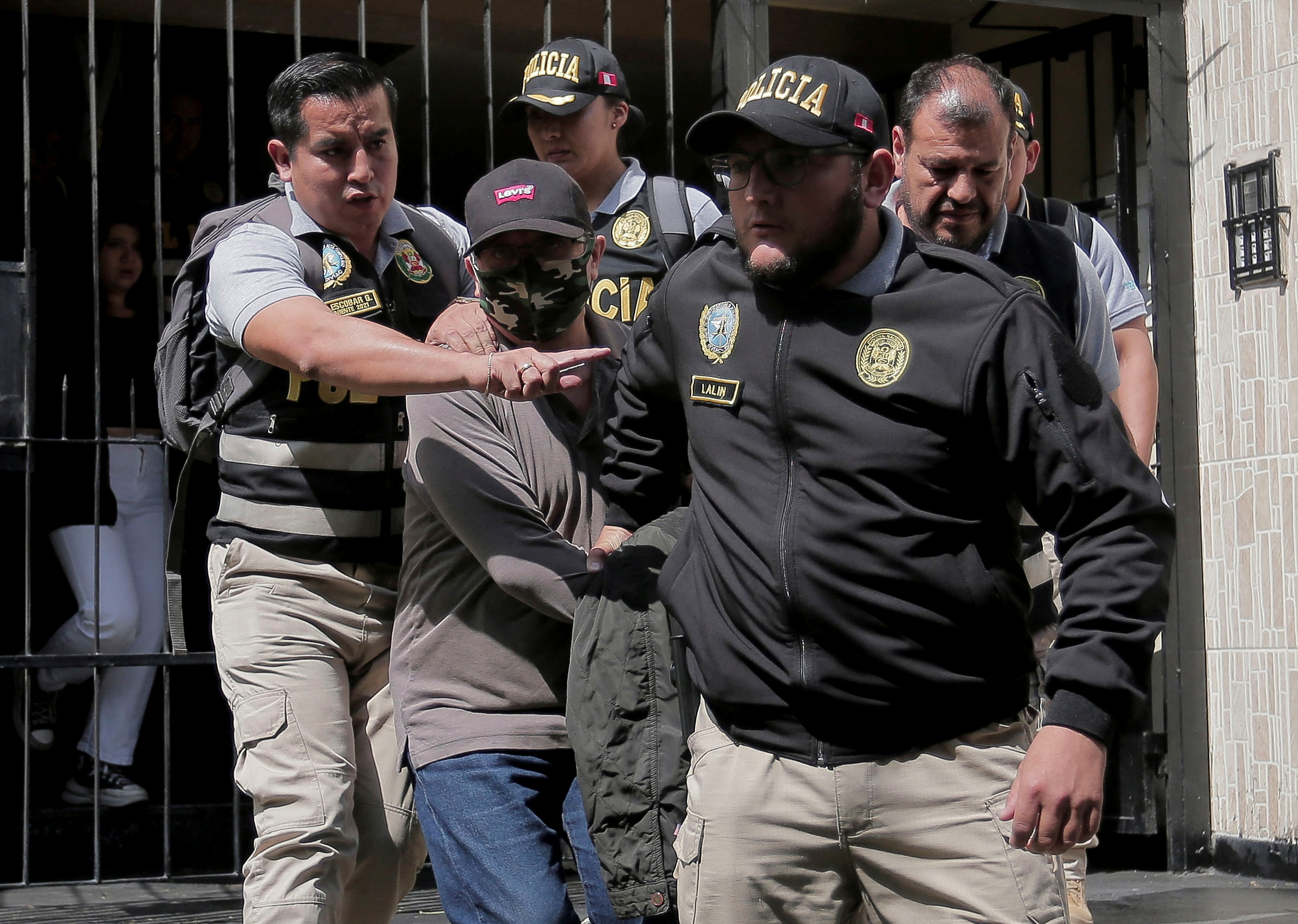 Police officers escort Nicanor Boluarte, brother of Peruvian President Dina Boluarte, in Lima