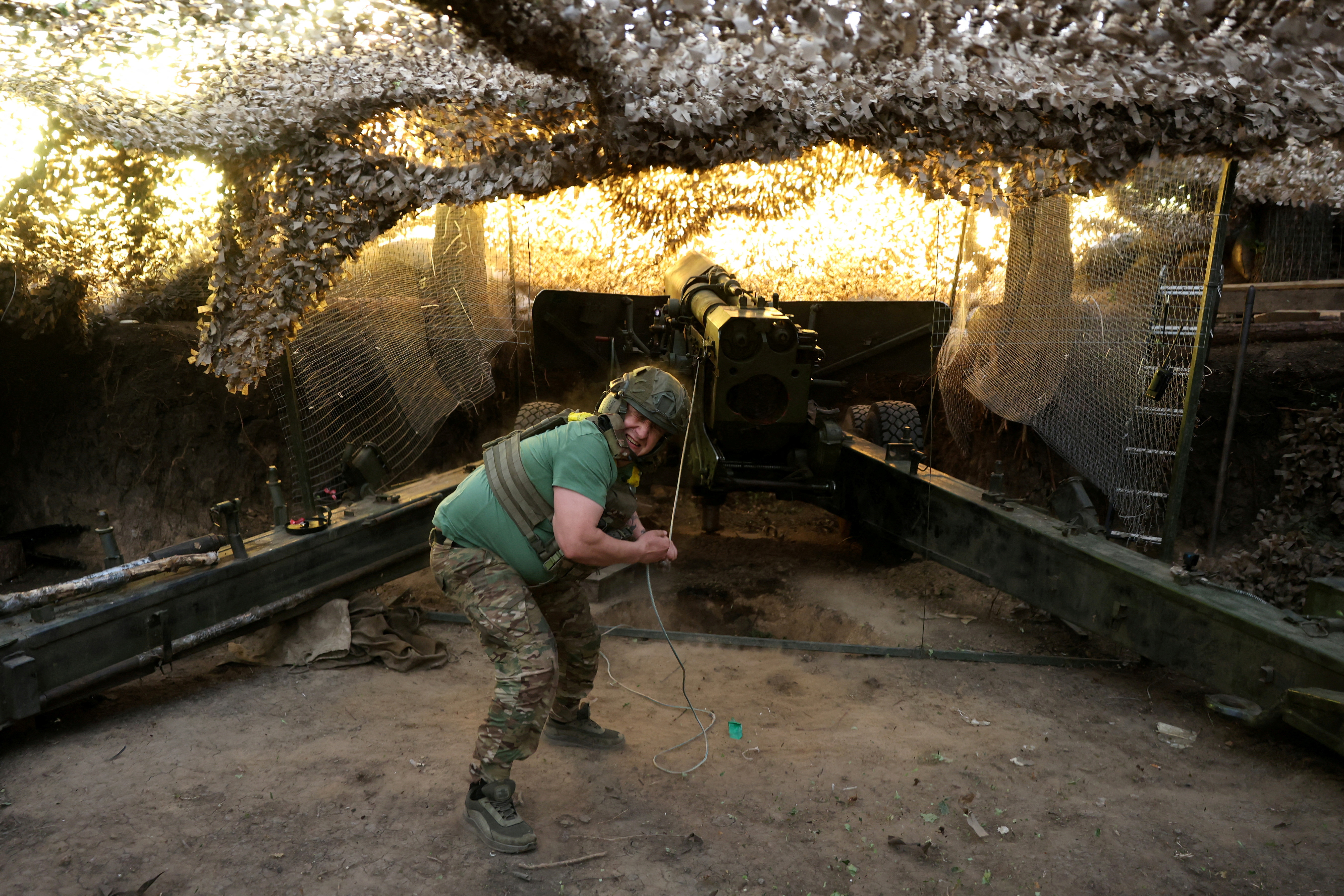 Ukrainian service members fire a 2A36 Giatsint-B howitzer towards Russian troops, at a position on a front line near the town of Kupiansk, in Kharkiv region