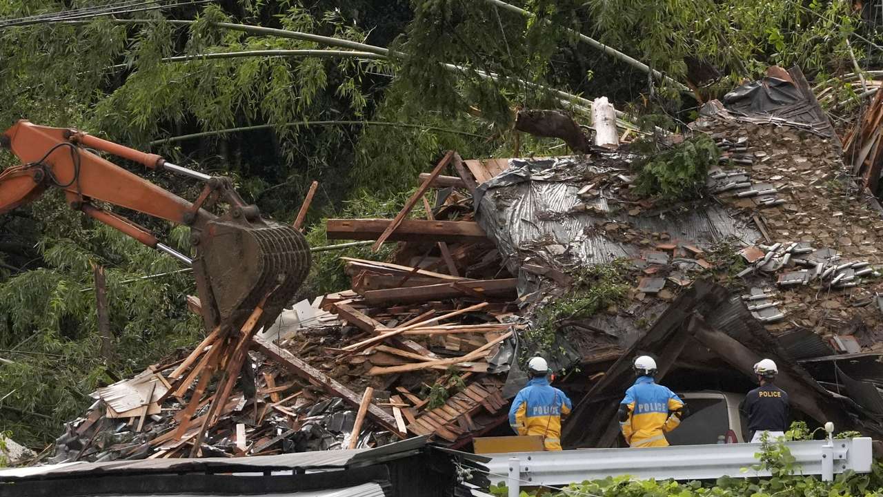 Police officers stand during a rescue operation at an area affected by landfall due to heavy rains caused by Typhoon Shanshan in Gamagori, Aichi prefecture