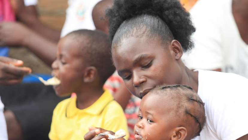 A mother feeds her child with traditional porridge, in Kotwa, Mudzi district