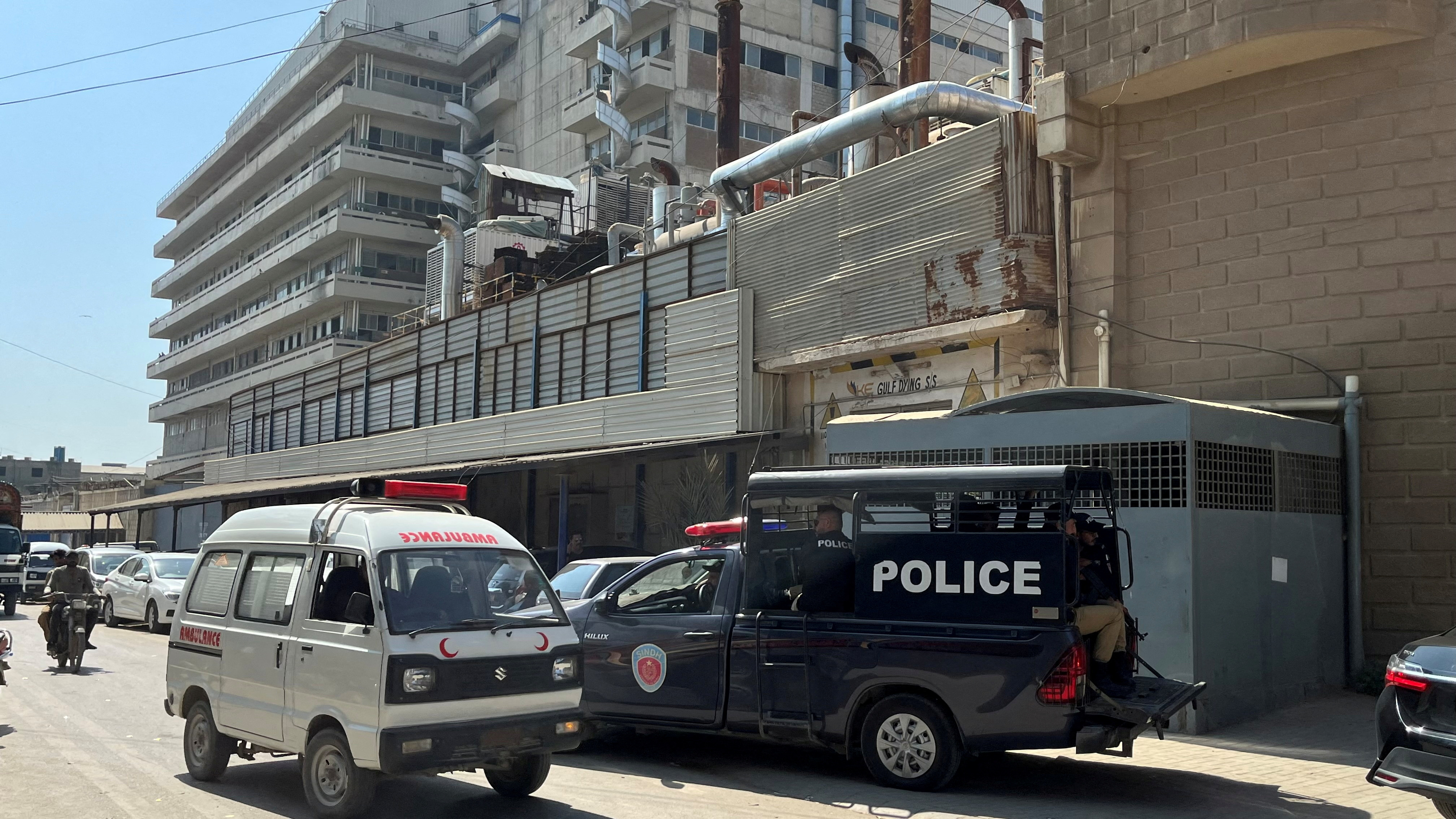 A view of police mobile and an ambulance outside a factory where according to police, two Chinese nationals were shot at and injured, in Karachi