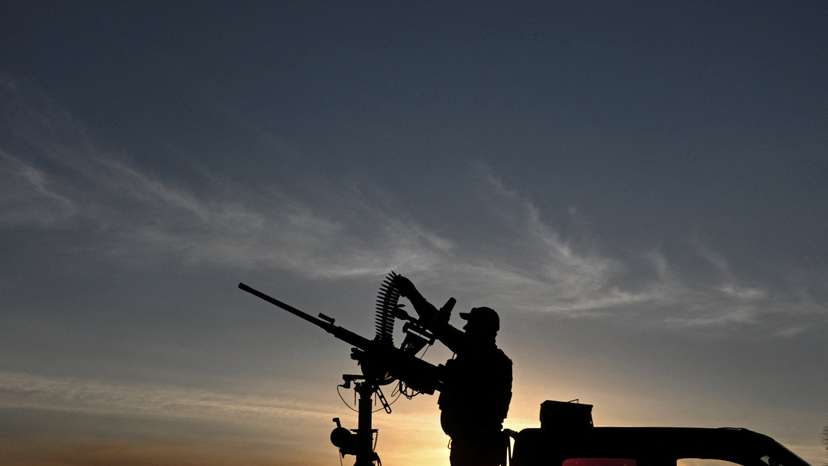 Ukrainian serviceman loads cartridges into a machine gun during a combat shift in a front line in Kharkiv region