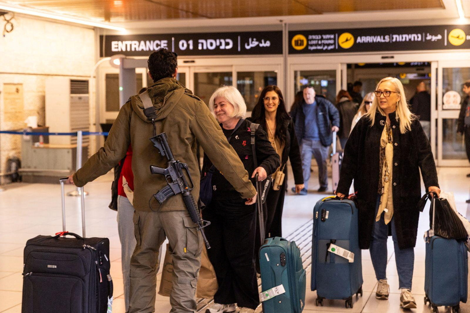 An Israeli soldier greets loved ones who returned to Israel from Italy on one of the first flights since Israel's airspace reopened, amid the U.S.-Israel conflict with Iran, at Ben Gurion International airport in Lod