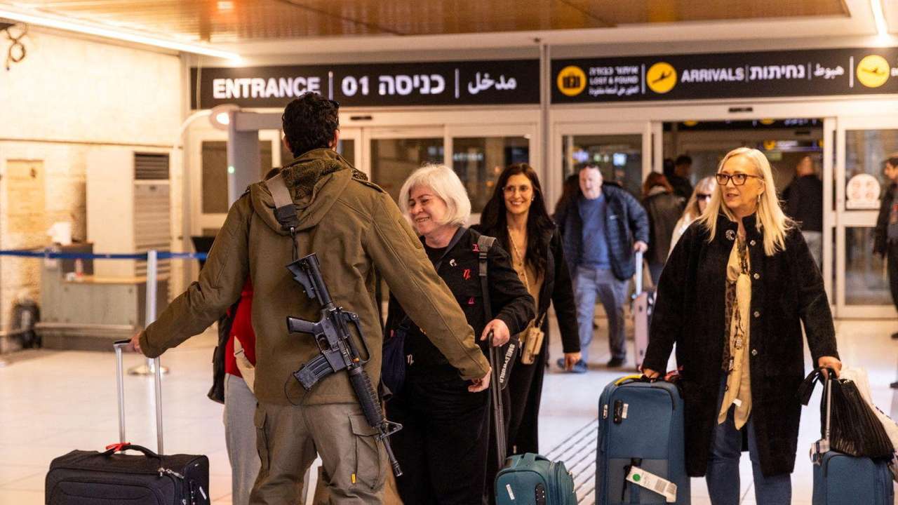 An Israeli soldier greets loved ones who returned to Israel from Italy on one of the first flights since Israel's airspace reopened, amid the U.S.-Israel conflict with Iran, at Ben Gurion International airport in Lod